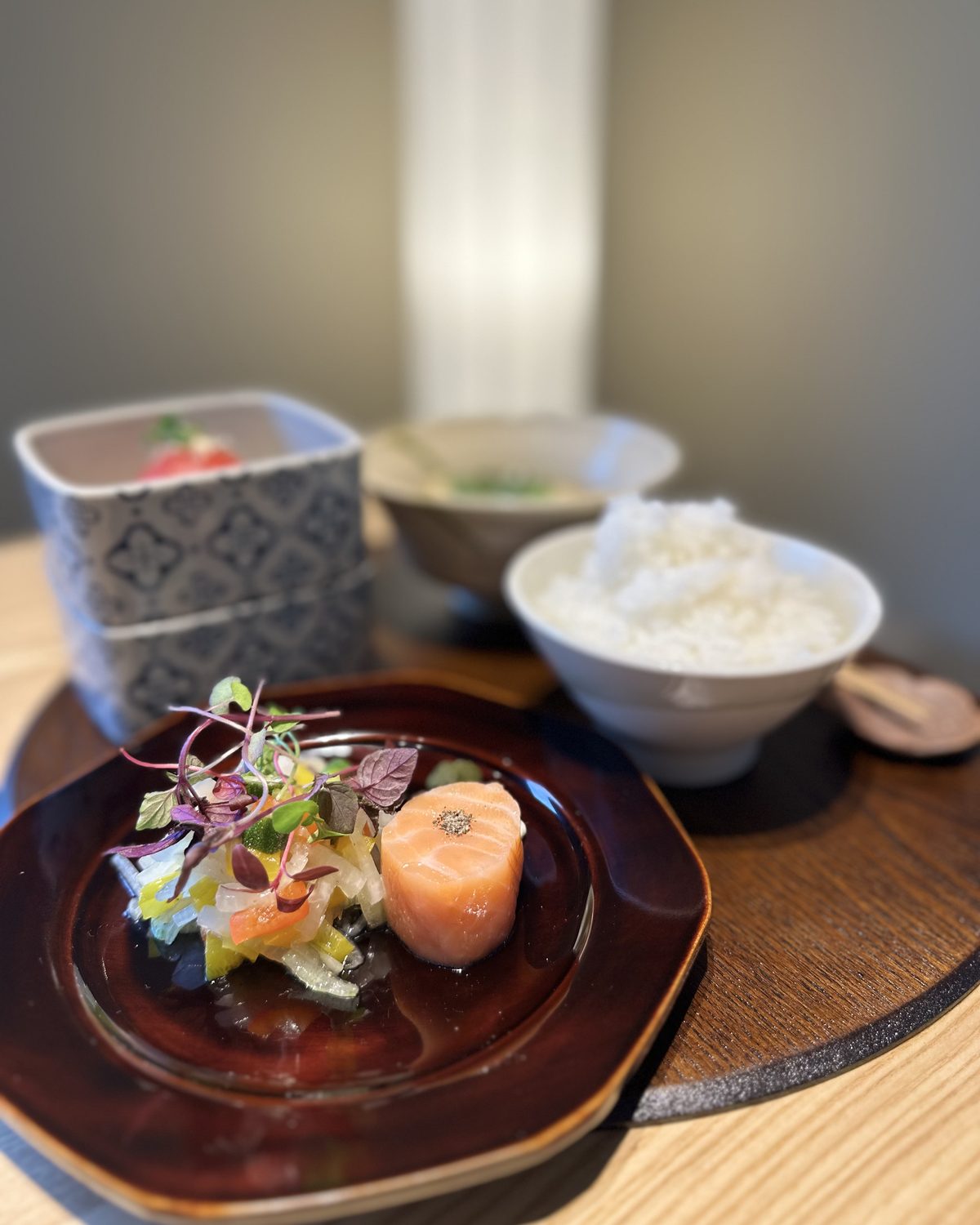 お昼の膳。漆の皿に前菜、土鍋で炊いたごはん